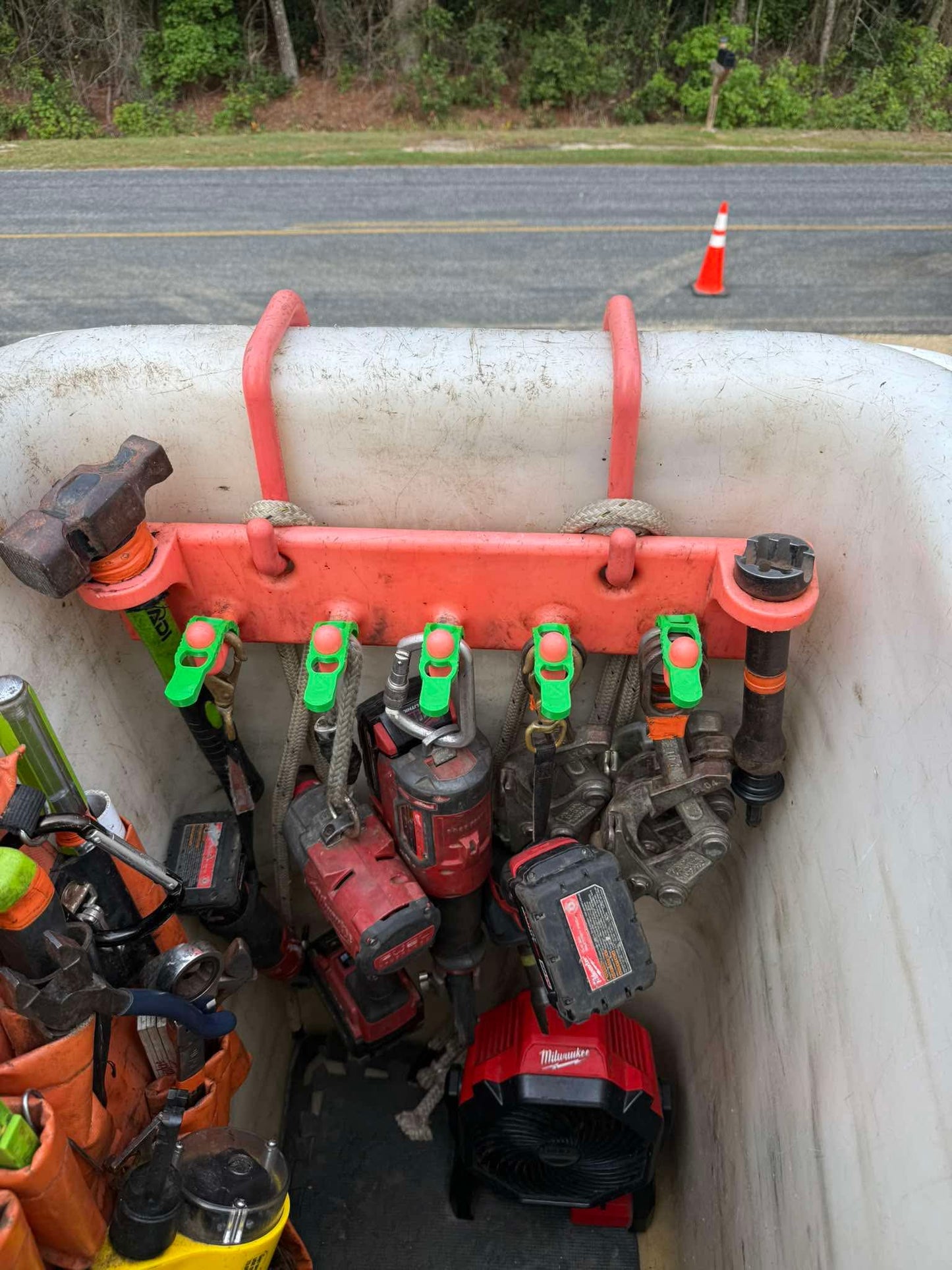 Five green Hook Keepers holding a customer's tools on a bucket rack