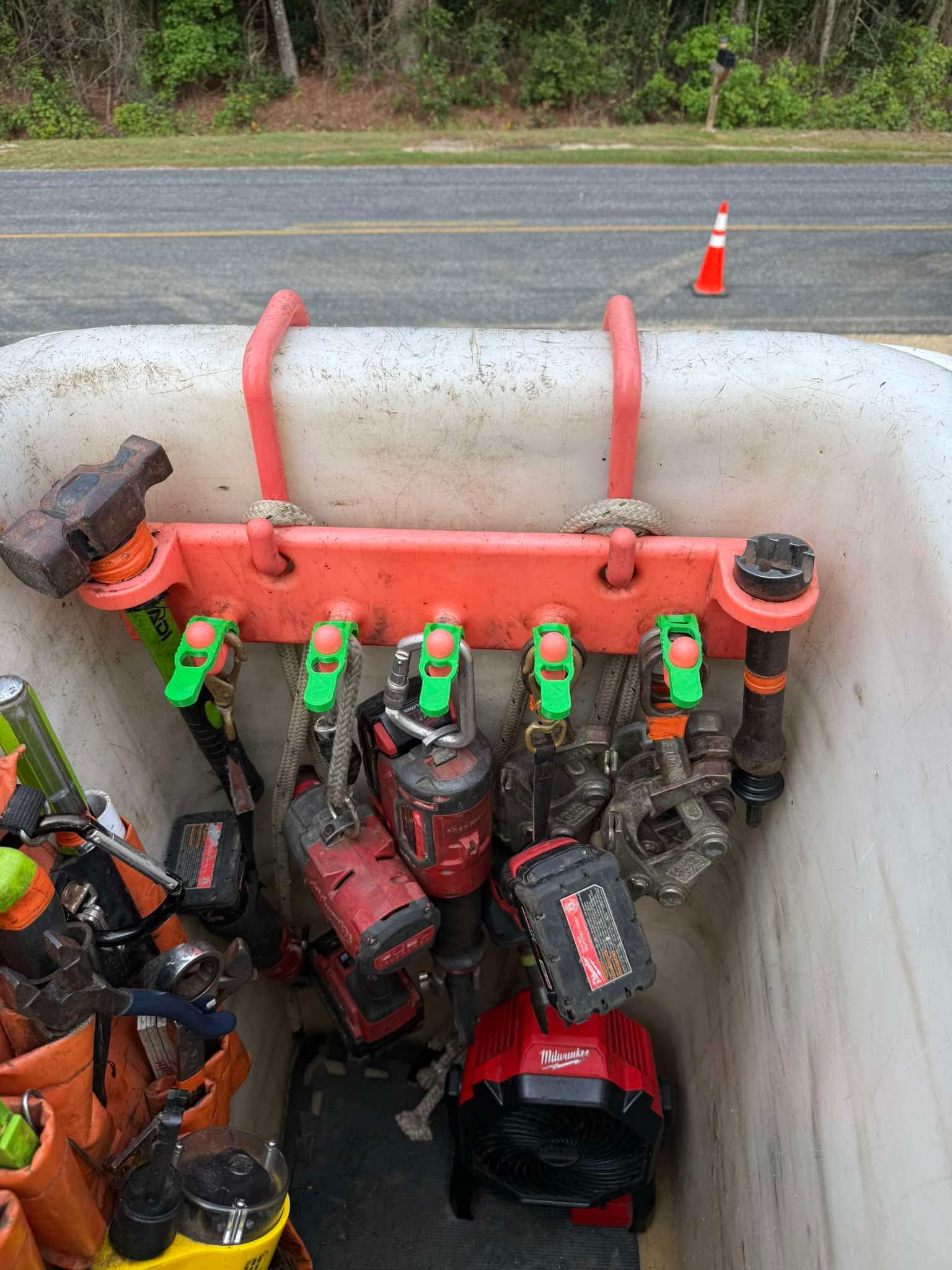 Five green Hook Keepers holding a customer's tools on a bucket rack